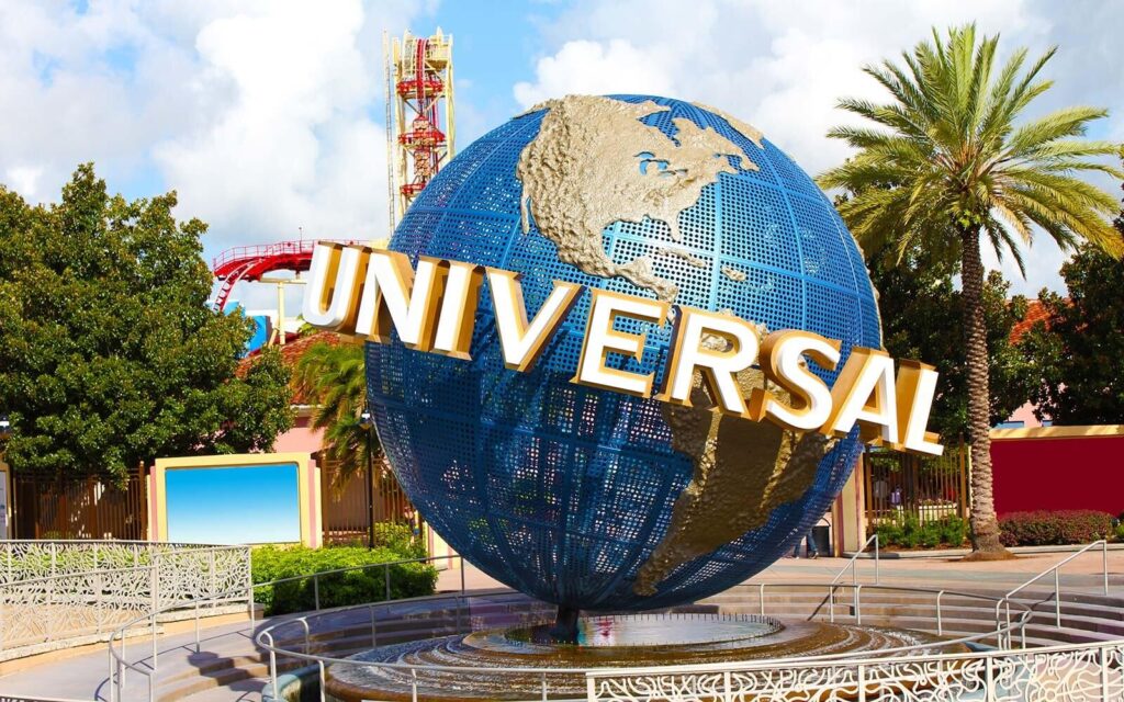 Iconic Universal Studios globe monument (USJ) surrounded by palm trees and roller coaster tracks in the background, symbolizing entrance to the theme park.