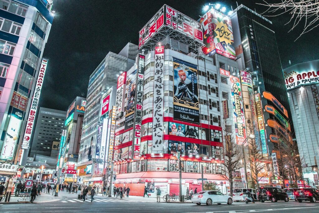 Explore the vibrant cityscape of Shinjuku, Tokyo at night with bright neon lights and bustling streets.