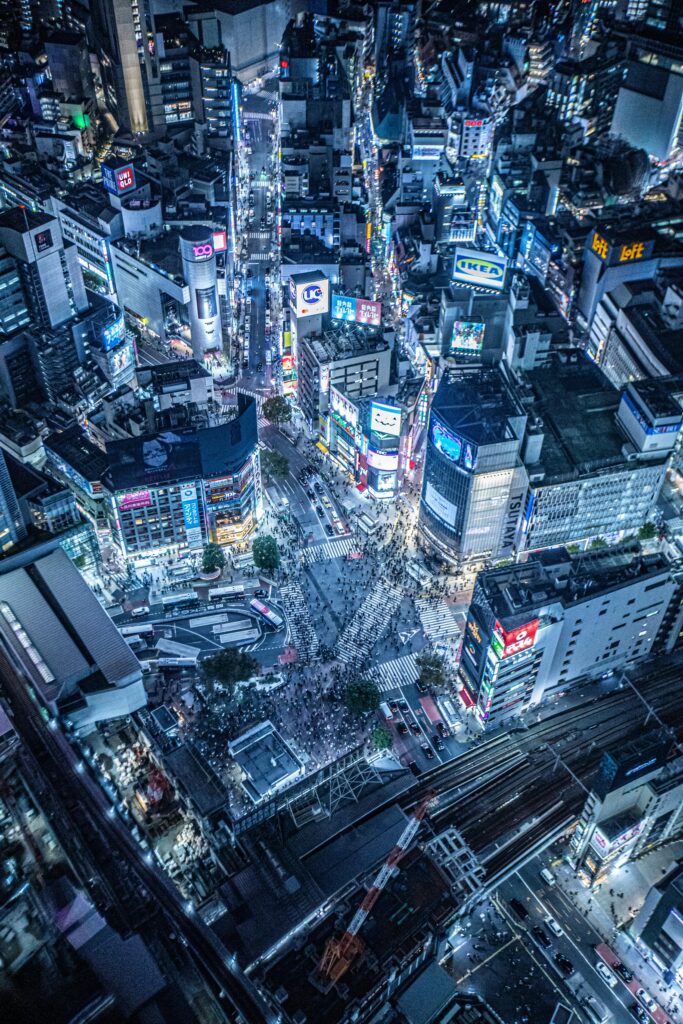 Vibrant aerial cityscape showcasing the bustling Shibuya Crossing at night in Tokyo, Japan.