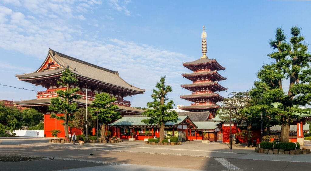 Sunny view of Senso-ji Temple and Five-Storied Pagoda in Tokyo, showcasing traditional Japanese architecture.